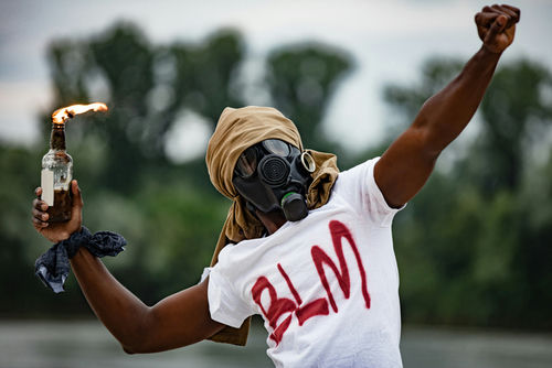Person in gas mask with Molotov cocktail, BLM shirt.