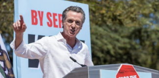 Gavin Newsom speaking at a podium, Stop the Republican Recall.