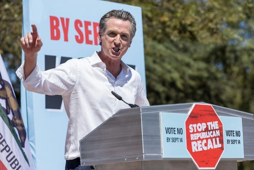 Gavin Newsom speaking at a podium, Stop the Republican Recall.