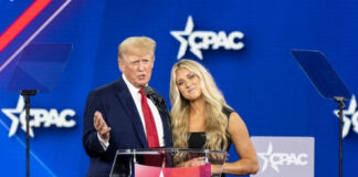 Two people speaking at CPAC event stage.