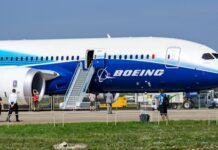 Boeing 787 airplane at an airport with passengers boarding
