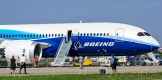 Boeing 787 airplane at an airport with passengers boarding