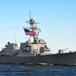 Pentagon’s Quiet Cuba Buildup: What’s REALLY Happening? naval destroyer with flags sailing on open water