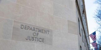 Department of Justice building with American flags outside.