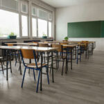 Elementary Hire After Kissing Scandal? Empty classroom with desks, chairs, windows, and chalkboard.