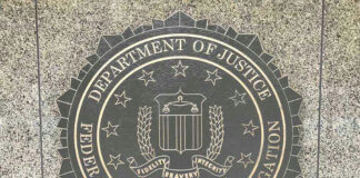 Department of Justice, FBI seal on stone background.
