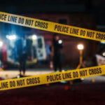 Yellow police tape at a nighttime crime scene.