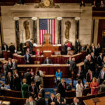 Large group in U.S. Congress chamber, American flag displayed.