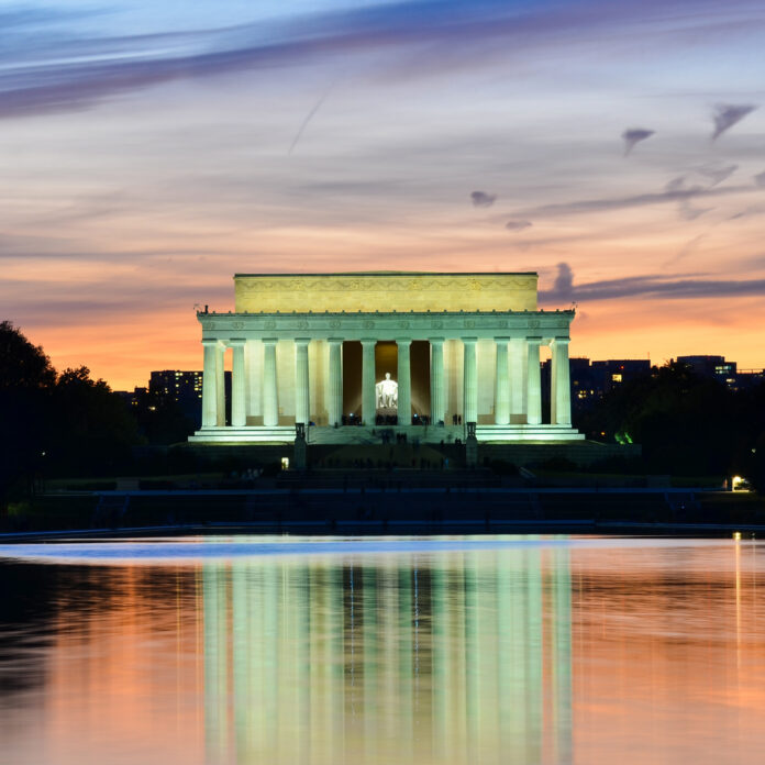 Lincoln Memorial illuminated at sunset with reflection in water
