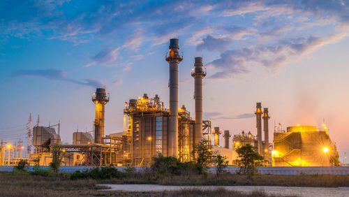 Industrial plant with smokestacks at dusk.