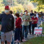 People standing in line for curbside voting on an autumn day