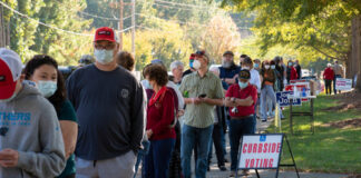 People standing in line for curbside voting on an autumn day