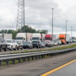 A long line of trucks and cars stuck in traffic on a highway