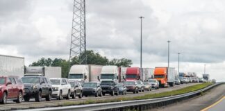 A long line of trucks and cars stuck in traffic on a highway