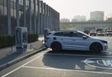 A silver electric vehicle charging at a station in a parking lot