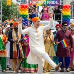 Participants in traditional attire celebrating at a Pride parade