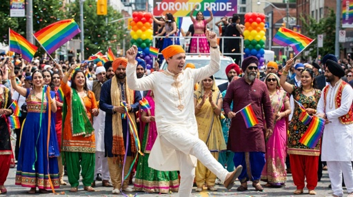 Participants in traditional attire celebrating at a Pride parade