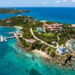 Aerial view of a tropical island with luxury villas and clear blue waters