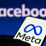 Smartphone displaying Meta logo with Facebook in background.