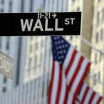 Wall Street sign with American flag in background