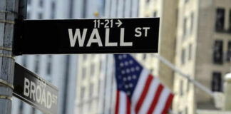 Wall Street sign with American flag in background