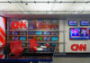 Network Blackout Ignites Trump Showdown CNN World Headquarters studio with empty red chairs.