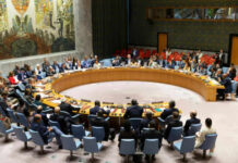 Power Vacuum: Hawks vs. America First UN Security Council meeting in session, multiple representatives attending.