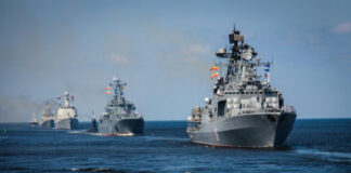 Several naval warships sailing in the ocean.