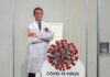 Cardboard cutout of doctor with COVID-19 virus info display