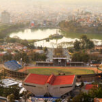 Aerial view of a stadium and a lake surrounded by a city