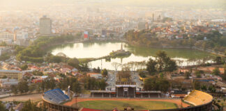 Aerial view of a stadium and a lake surrounded by a city
