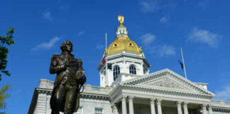 New Hampshire State House with statue in foreground.