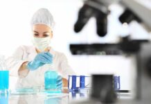 Scientist in lab coat handling blue liquid
