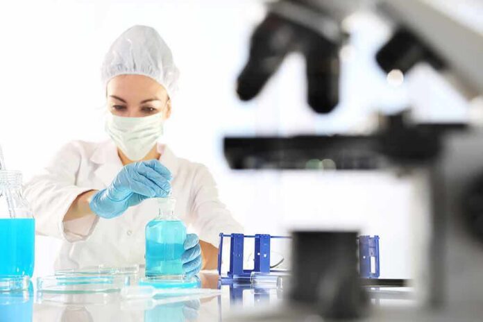 Scientist in lab coat handling blue liquid