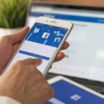 hands using a smartphone with a social media login screen