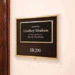 office wall plaque with black and gold nameplate and room number