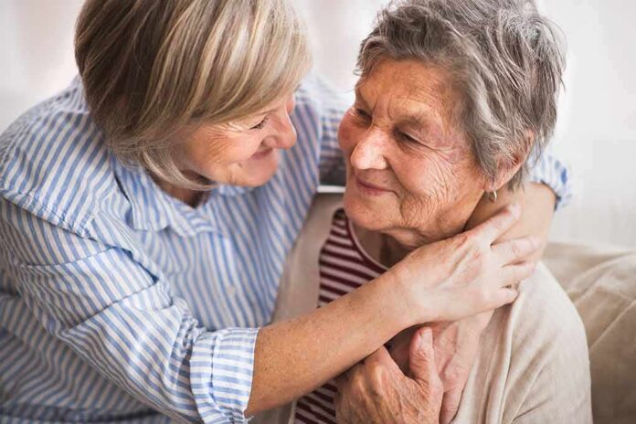 Two older women embracing and smiling on a couch