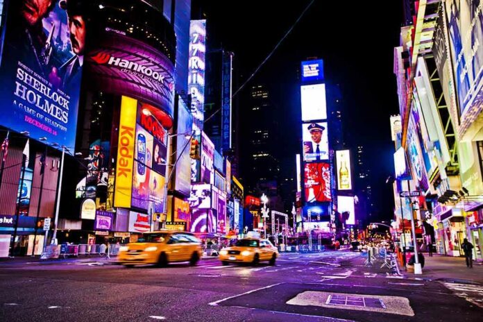 Times Square at night with bright billboards and yellow taxis