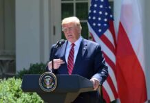 man at presidential podium speaking outdoors