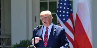 man at presidential podium speaking outdoors