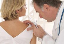 Melanoma Rebounds Crushed By Custom Shot Doctor examining a patients skin with a magnifying glass