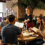 Server taking orders from a group at a restaurant table