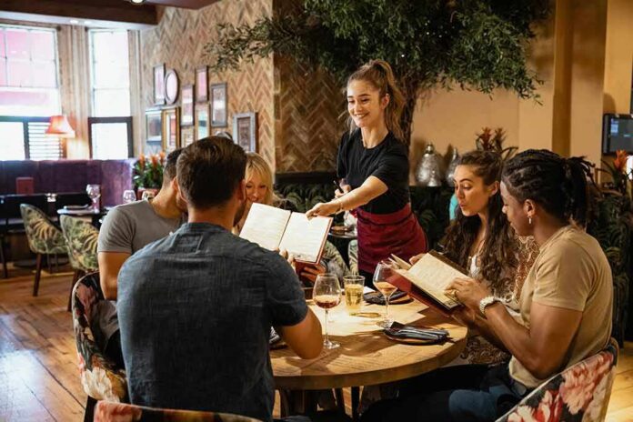 Server taking orders from a group at a restaurant table