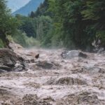 Flooded river gorge with fast muddy water and rocks