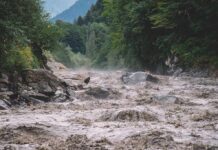 Flooded river gorge with fast muddy water and rocks