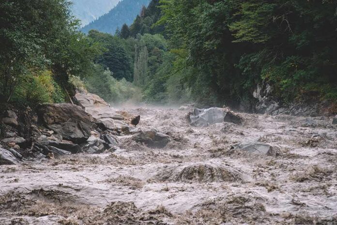 shutterstock_1732590473 Flooded river gorge with fast muddy water and rocks