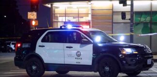 Police SUV blocks an intersection at night with lights flashing