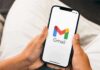 Hands holding a smartphone displaying the Gmail app logo