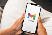 Gmail Lowers the Drawbridge Hands holding a smartphone displaying the Gmail app logo