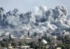 Massive smoke plumes rise over a city after explosions
